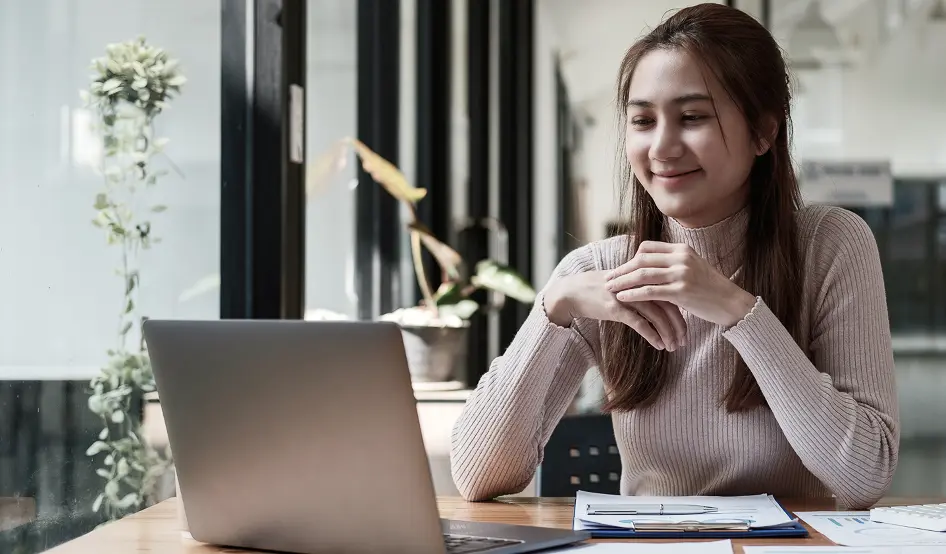 Smiling business owner looking at her laptop in a modern workspace in Greater Manchester, UK, representing confidence, digital success, and how My Digital Solutions – The Global Tech Hub® helps local businesses enhance online visibility and growth.