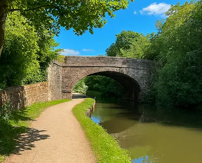 Rochdale Canal Towpath with arched stone bridge and peaceful waterway connecting Failsworth, Manchester, and Rochdale.