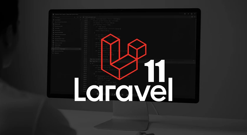 Developer working on Laravel 11 web application displayed on desktop monitor, highlighting advanced PHP framework features.